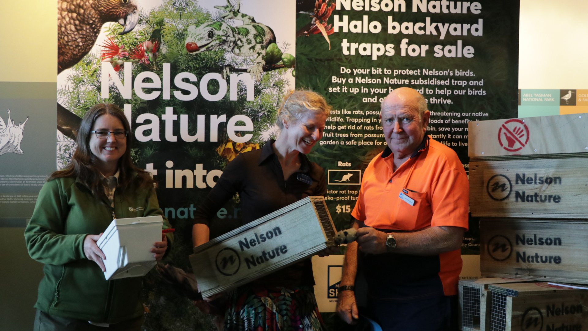 <br />
Amy Rutledge (DOC Ranger). Leigh Marshall (Team Leader Science and Environment)  and Colin Johnstone (Menzshed) with the trap display at the  Nelson i-Site.