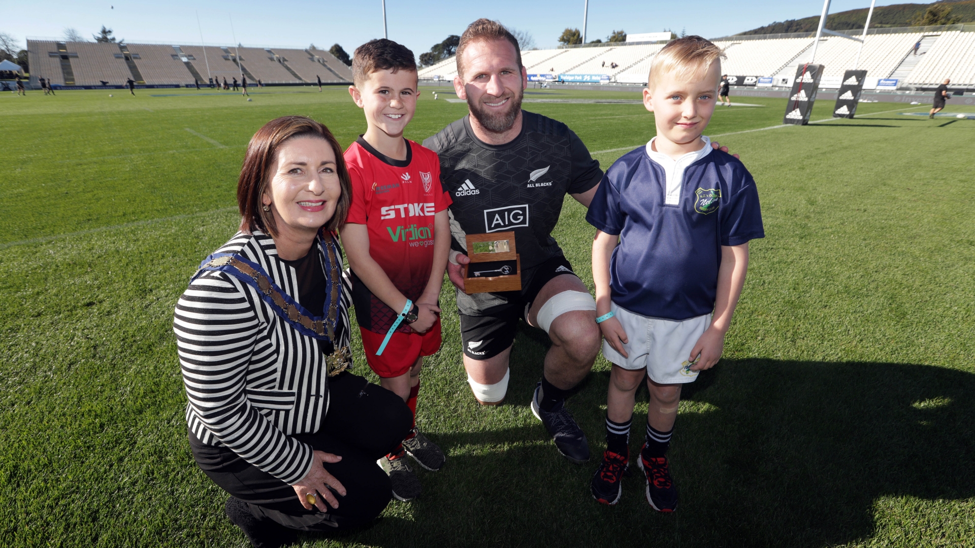 Mayor Rachel Reese presents the Key to the City to All Blacks captain Kieran Read, flanked by Rico Groome, 9, of Stoke Rugby Club, (red jersey) and Xavier Dickson-Paterson, 8, of Nelson Rugby Club (blue jersey).  